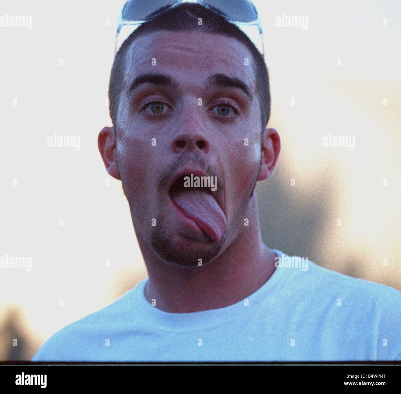 Robbie Williams sticking his tongue out to photographers at T in The Park festival Stock Photo