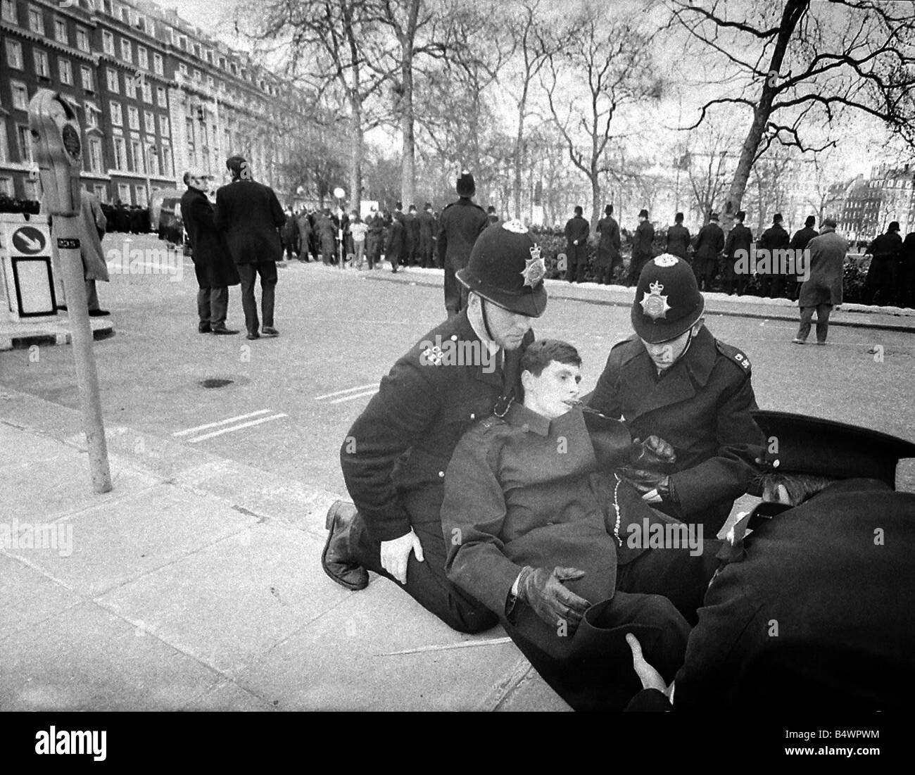 A demonstrator is led away during riots at US 'Embassy,' Grosvenor 'Square,' over the on-going Vietnam Conflict. March 1968 Stock Photo