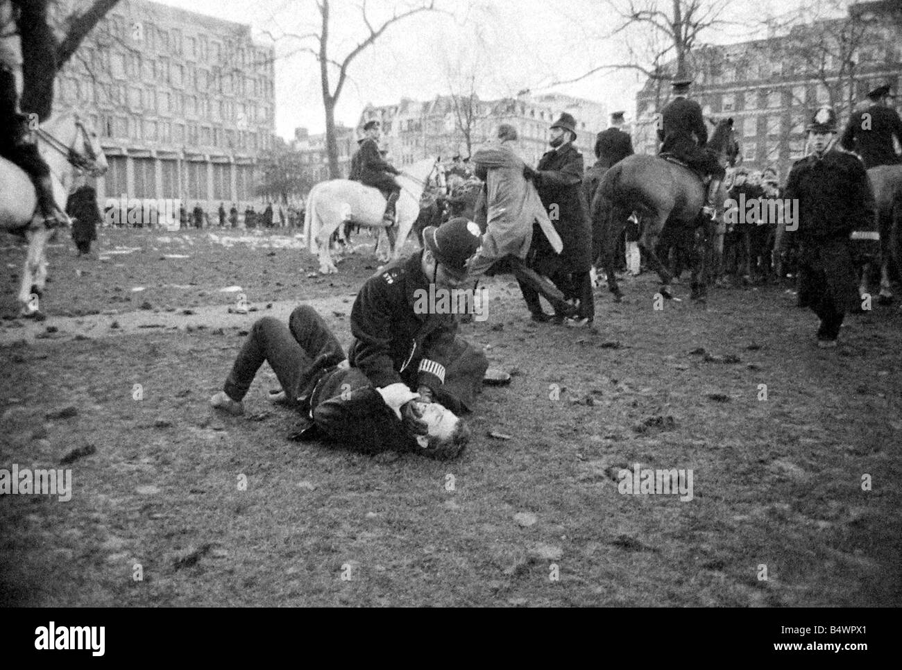 A policeman pins down a demonstrator during Riots at US Embassy, Grosvenor Square, over the on-going Vietnam Conflict.;Mar. 1968 Stock Photo