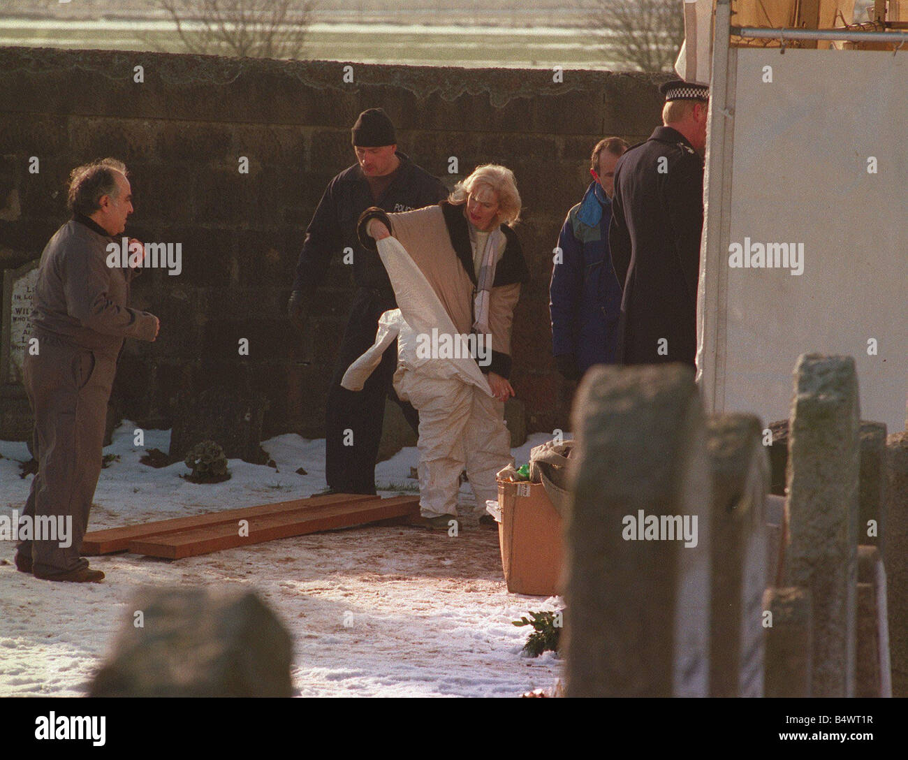 Dr Marie Cassidy pathologist changing into protective clothing during exhumation of John McInnes Bible John Stock Photo