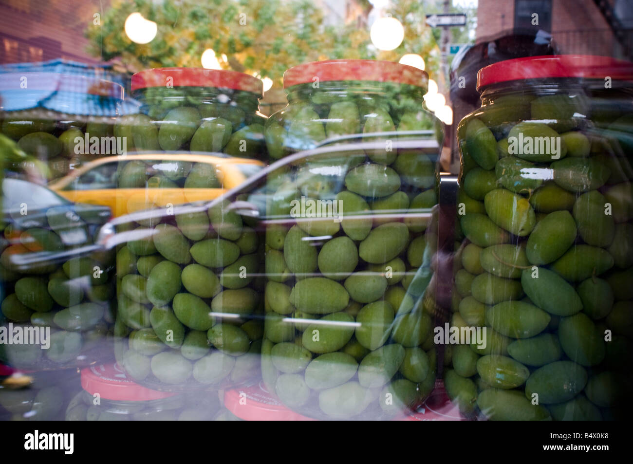 Deli store window large jars of green olives Stock Photo