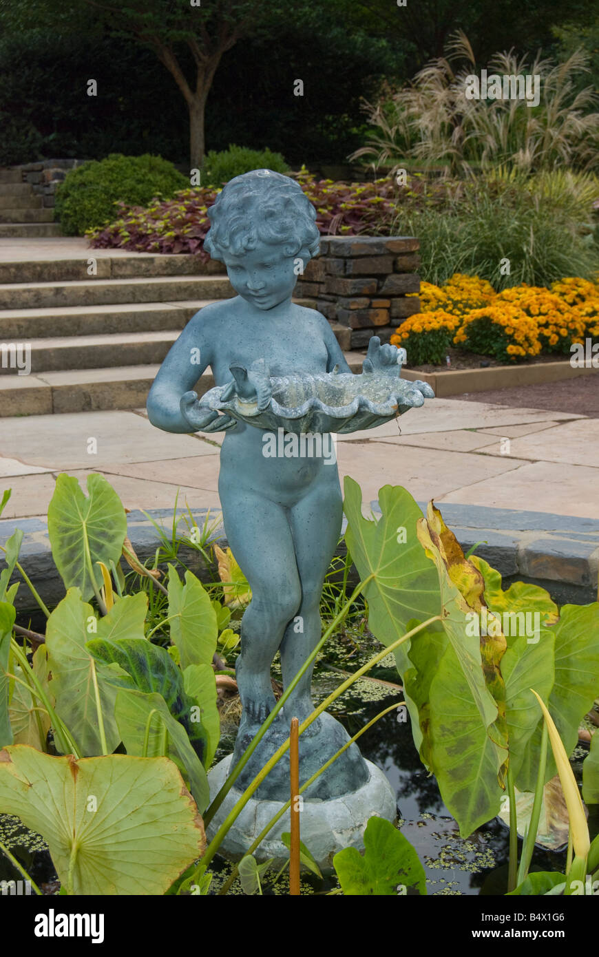 Statue of a boy holding a shell with coins in the Sarah P Duke Garden in Durham North Carolina Stock Photo