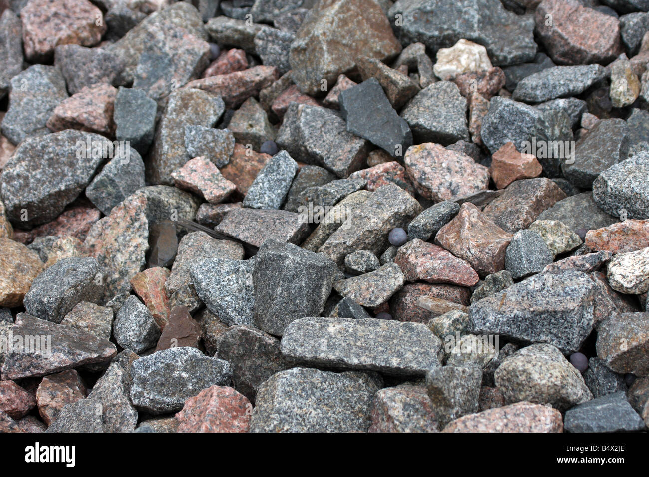 Granite stones and rocks in the bed of a railroad ties with iron ore pellet Stock Photo