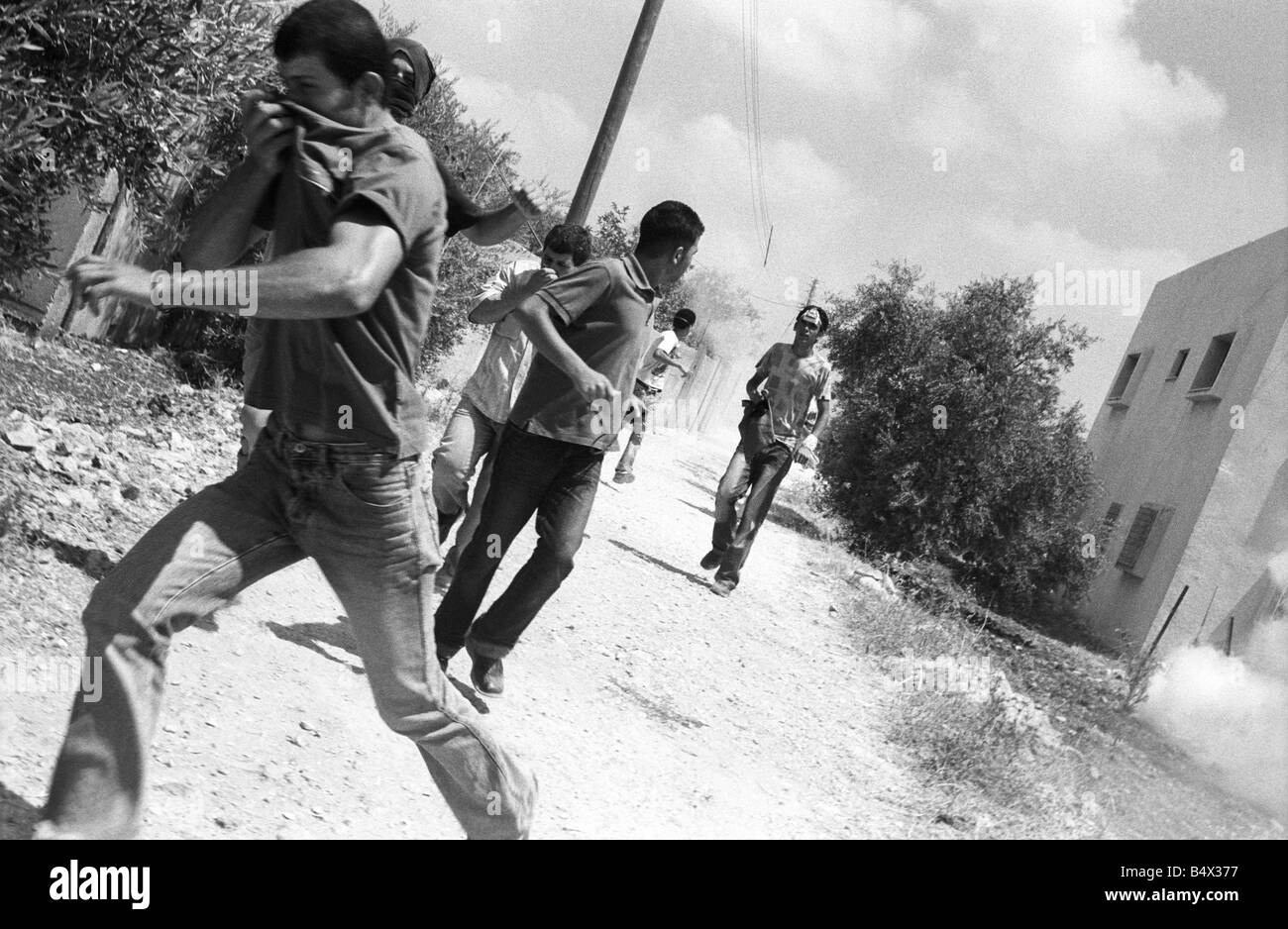 some palestinians running away from tear gas shot by israeli soldiers during a protest against the israelis building the separat Stock Photo