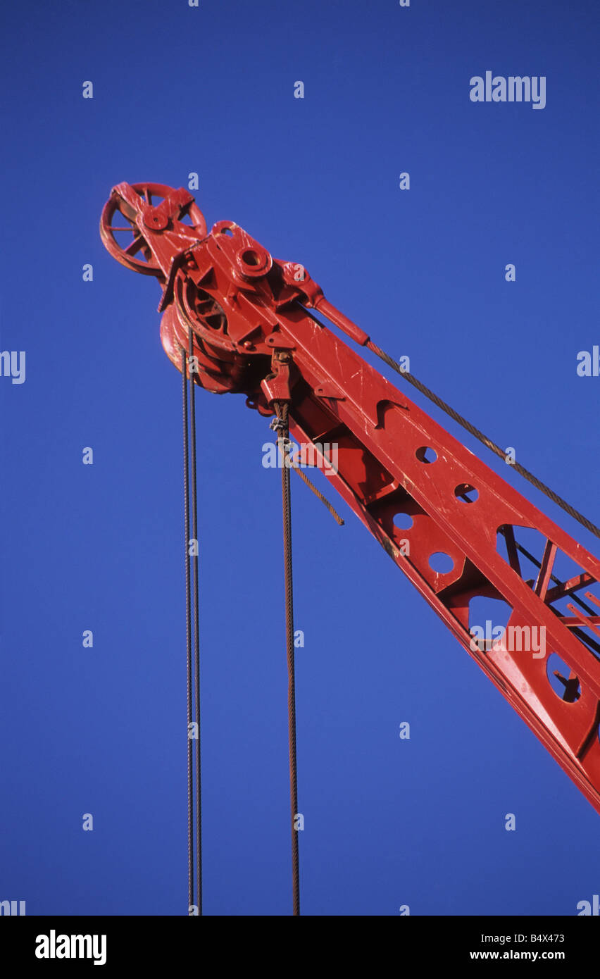 Detail of red crane, pulley and cables against blue sky in harbour , Iquique , Chile Stock Photo