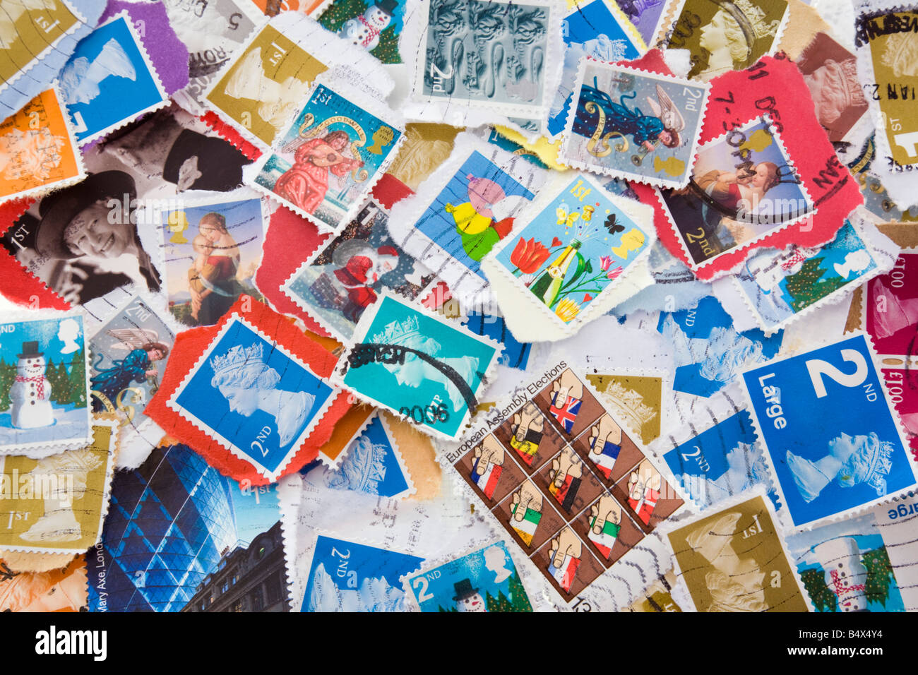 A colourful selection of various used British Royal Mail postage stamps in close-up. England UK Britain Stock Photo