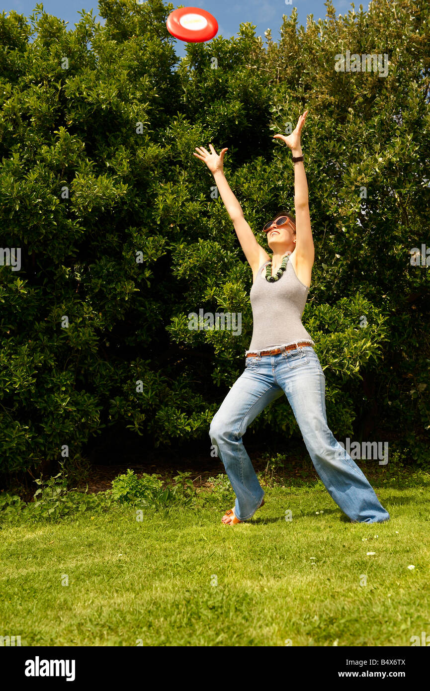 Young woman trying to catch a frisbee Stock Photo