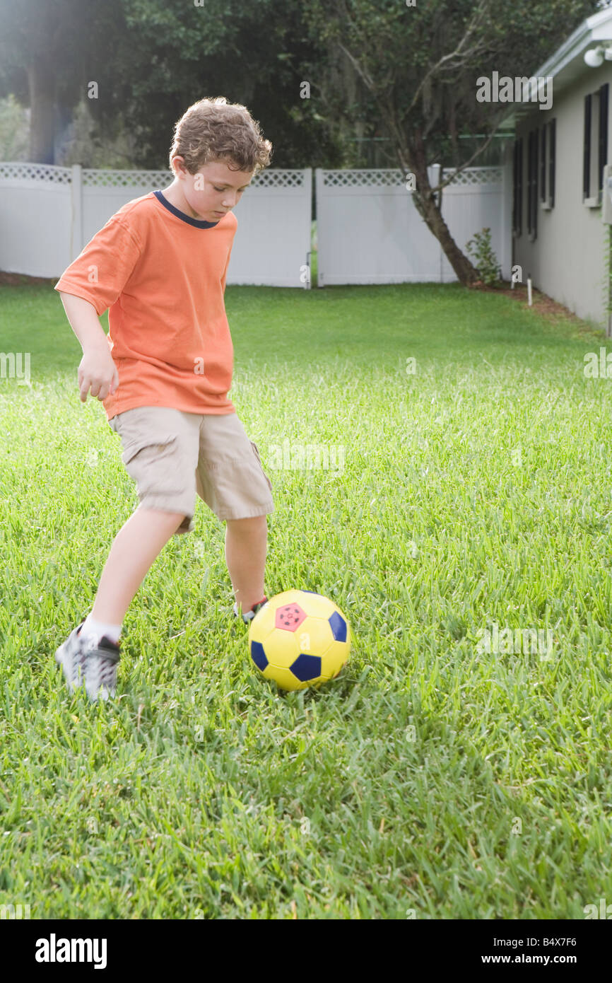 Boy playing in soccer in backyard Stock Photo