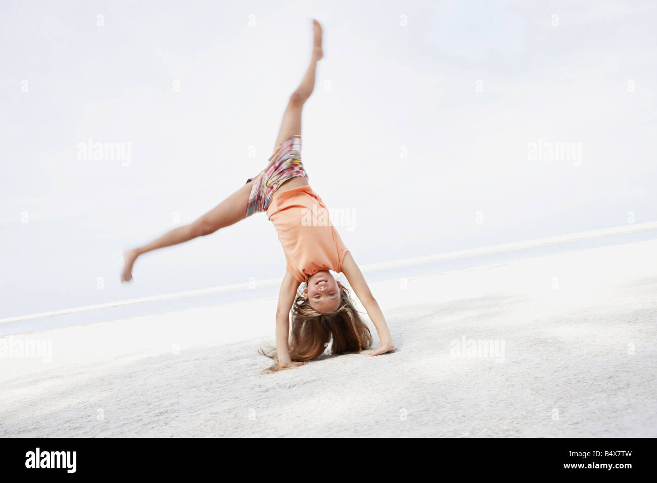Girl doing cartwheel on beach Stock Photo Alamy