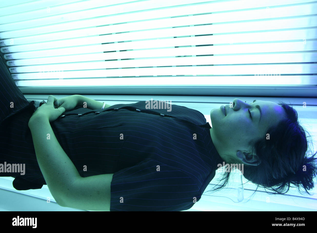 a portrait of a beautiful young woman laying on a sun bed in a tanning