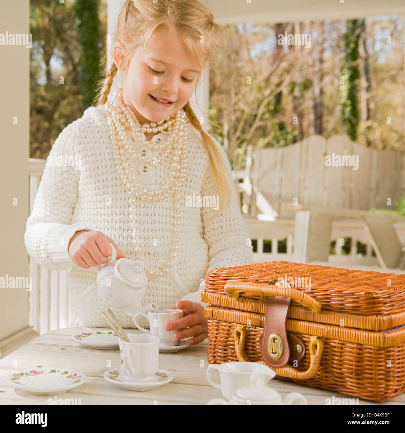Girl having tea party on porch Stock Photo - Alamy