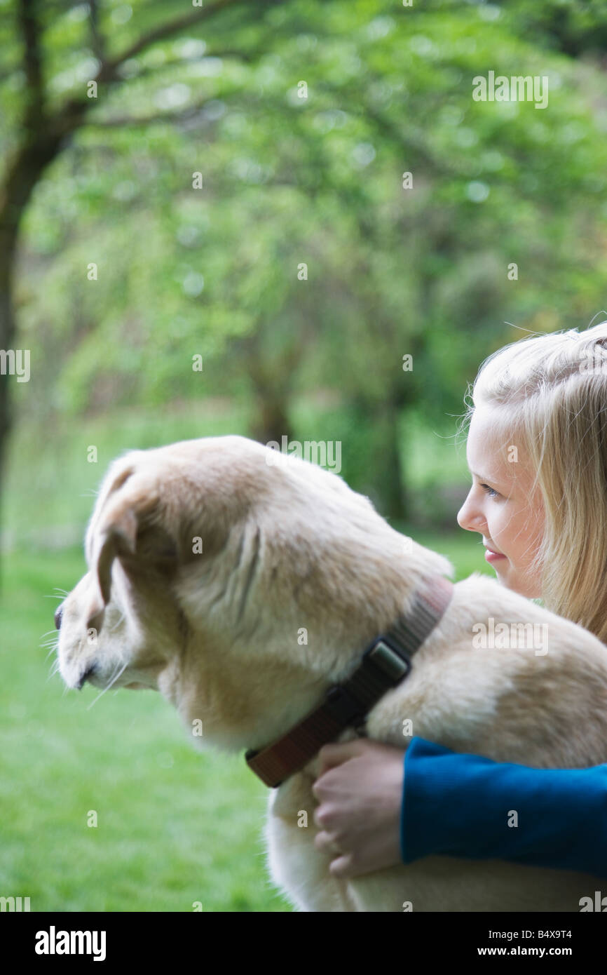 Girl hugging dog in park Stock Photo - Alamy