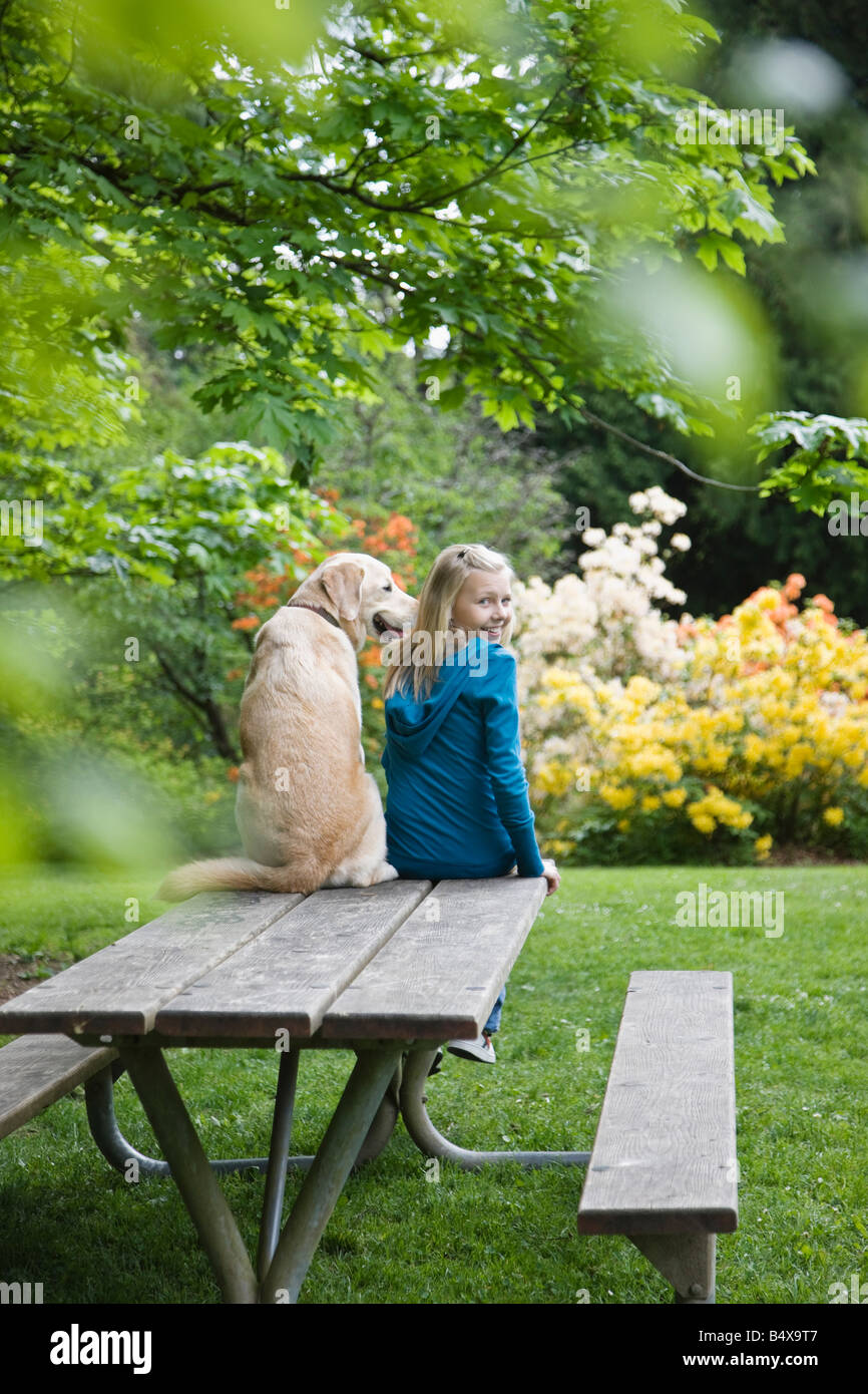 Girl and dog sitting on park bench Stock Photo - Alamy