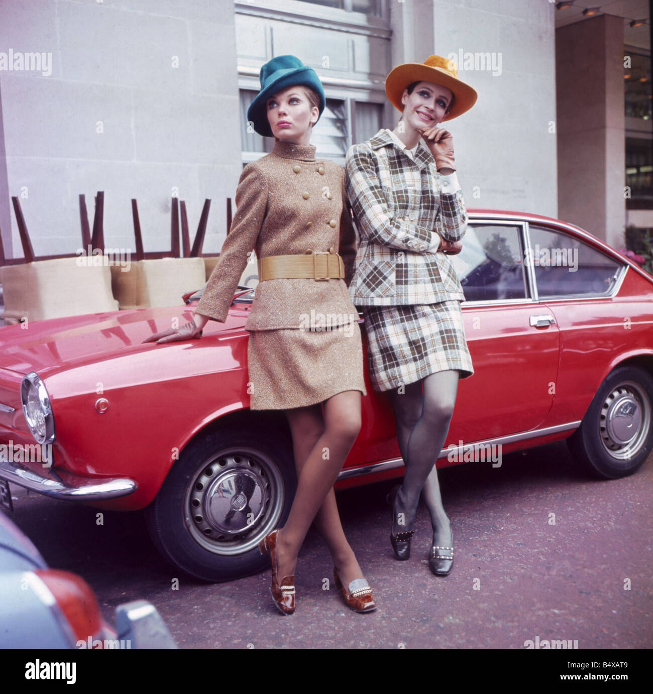 Sixties Fashion 1960s clothing Women with hats leaning on car Wool Trends International Show featuring Irish Tweed fashions Stock Photo
