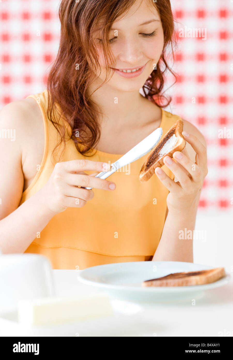 Teenage girl making toast Stock Photo