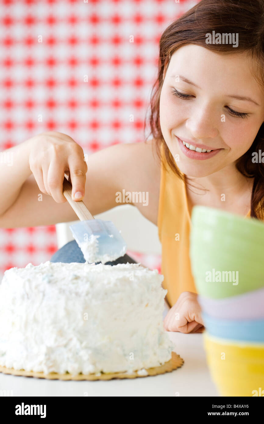 Teenage girl frosting cake Stock Photo