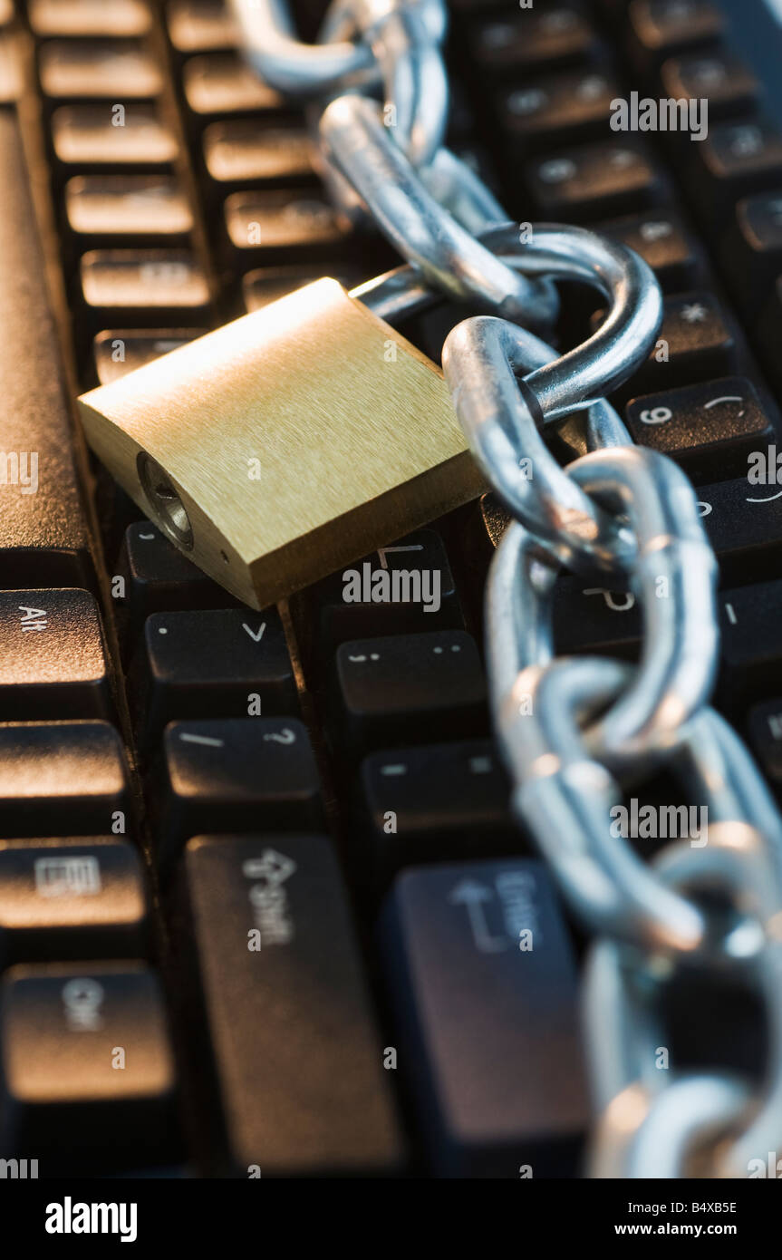 Close up of lock and chain on computer keyboard Stock Photo - Alamy