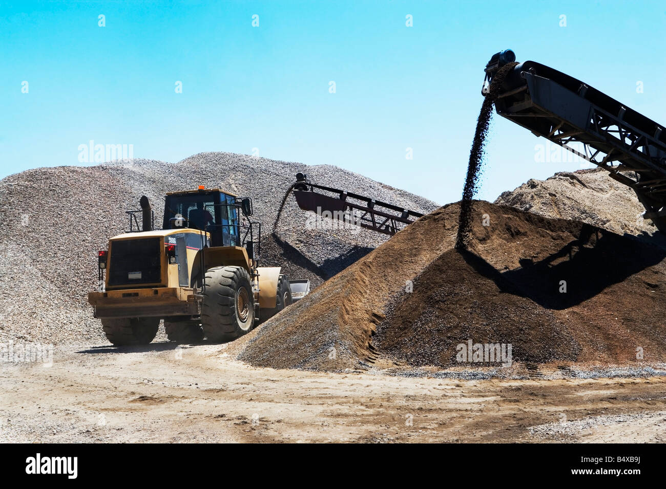 Bucket loader moving pile of gravel Stock Photo Alamy