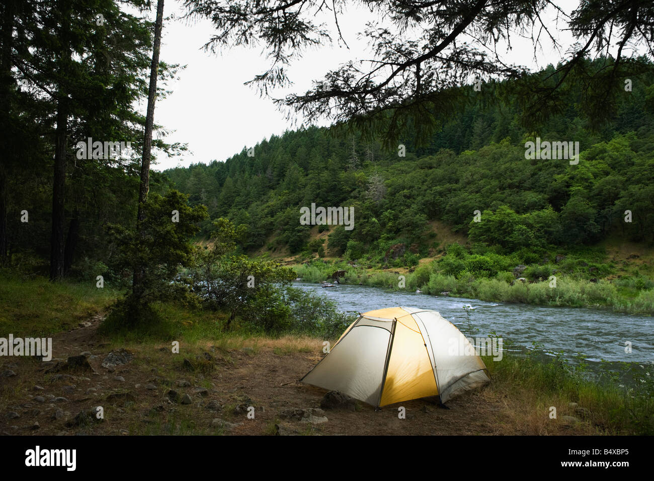 Tent and campsite by river Stock Photo - Alamy