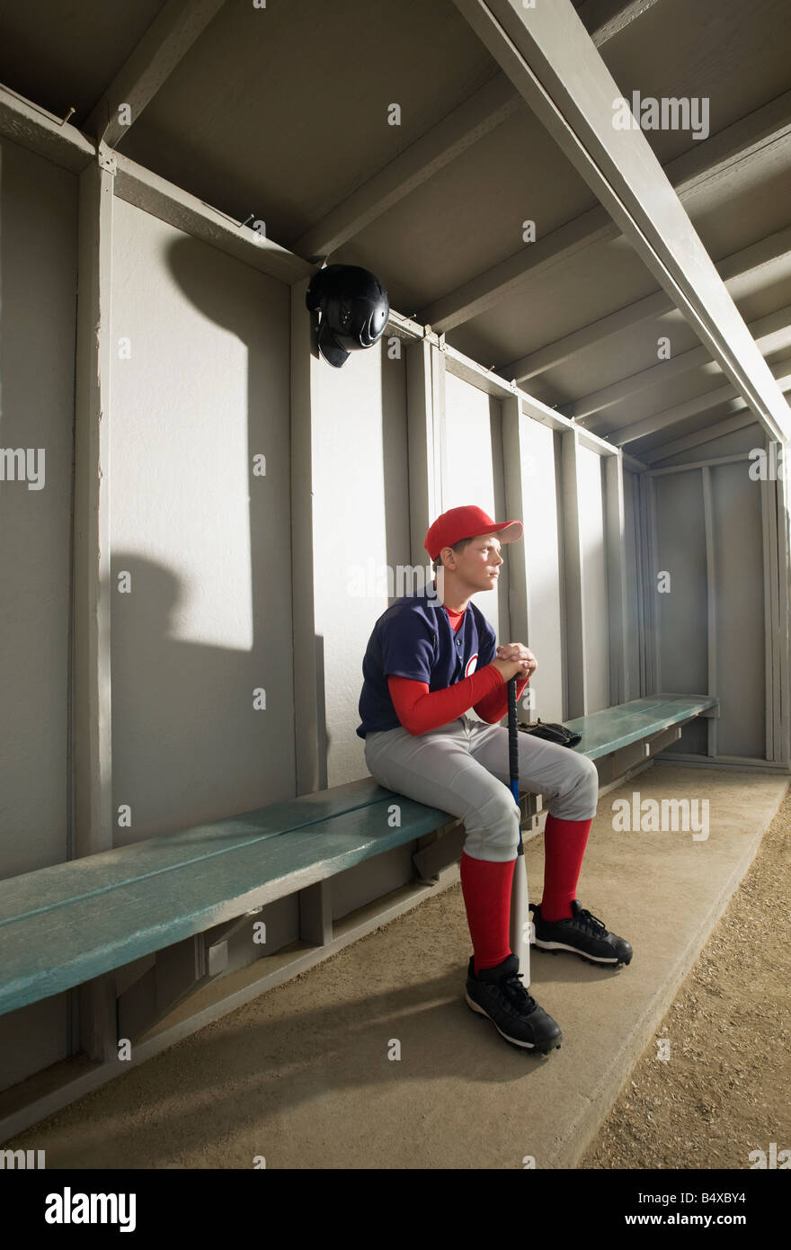 Serious baseball player sitting in dugout Stock Photo Alamy