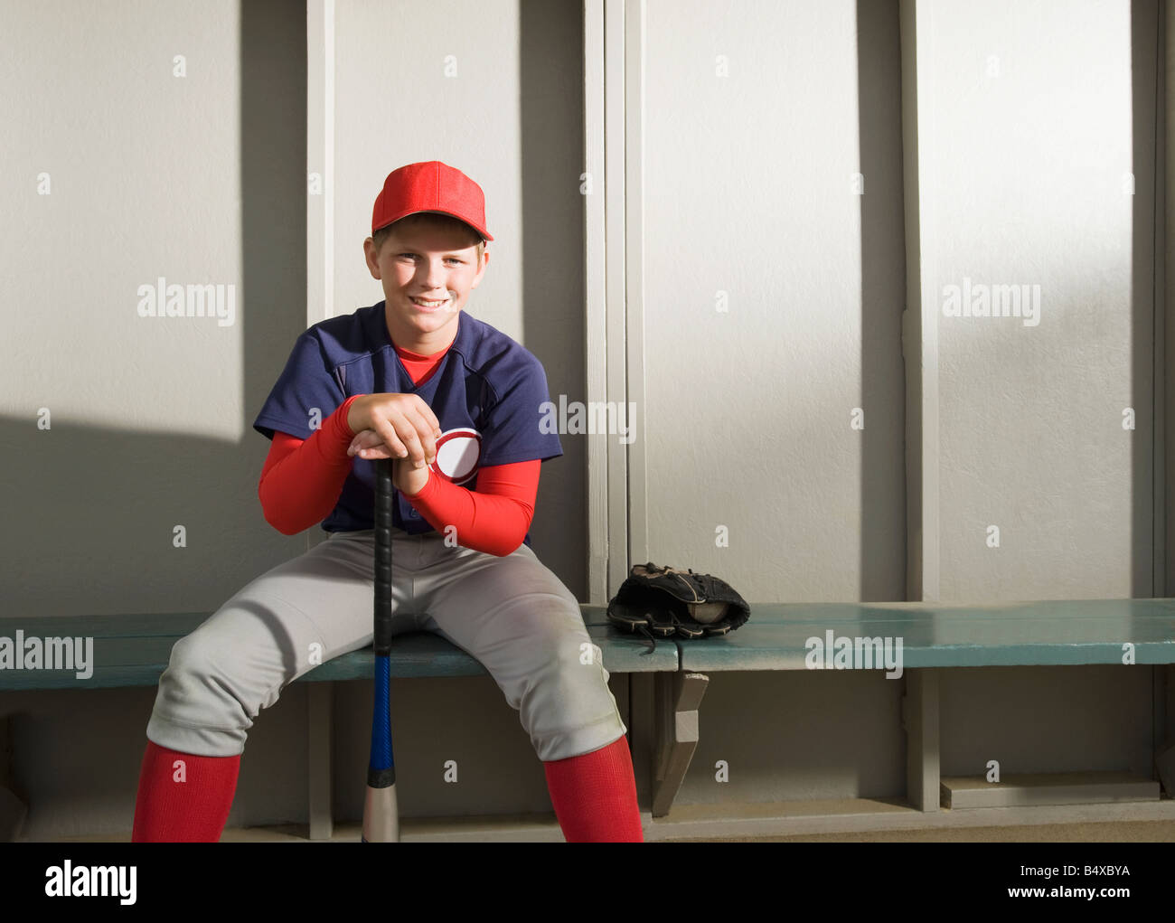 Baseball player sitting in dugout Stock Photo Alamy