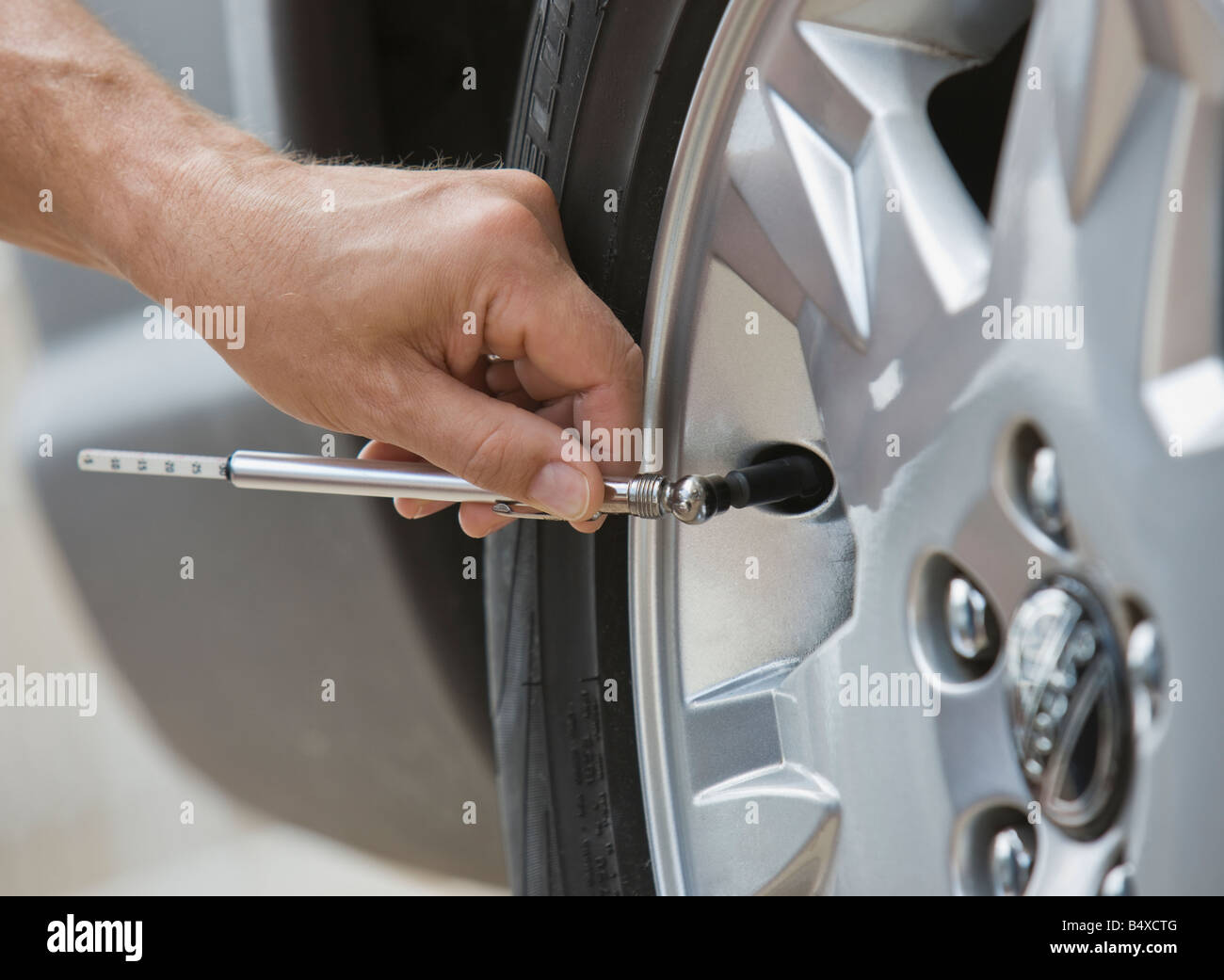 man-checking-car-tire-pressure-B4XCTG.jpg