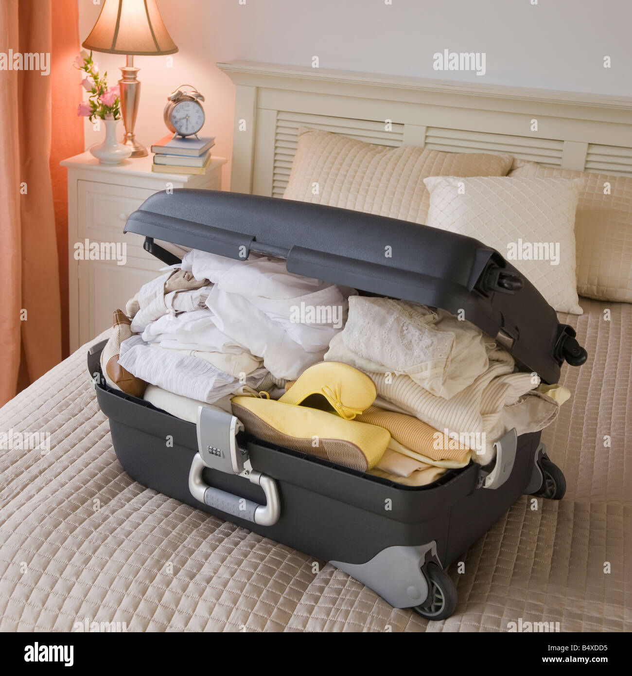 Full suitcase on bed Stock Photo
