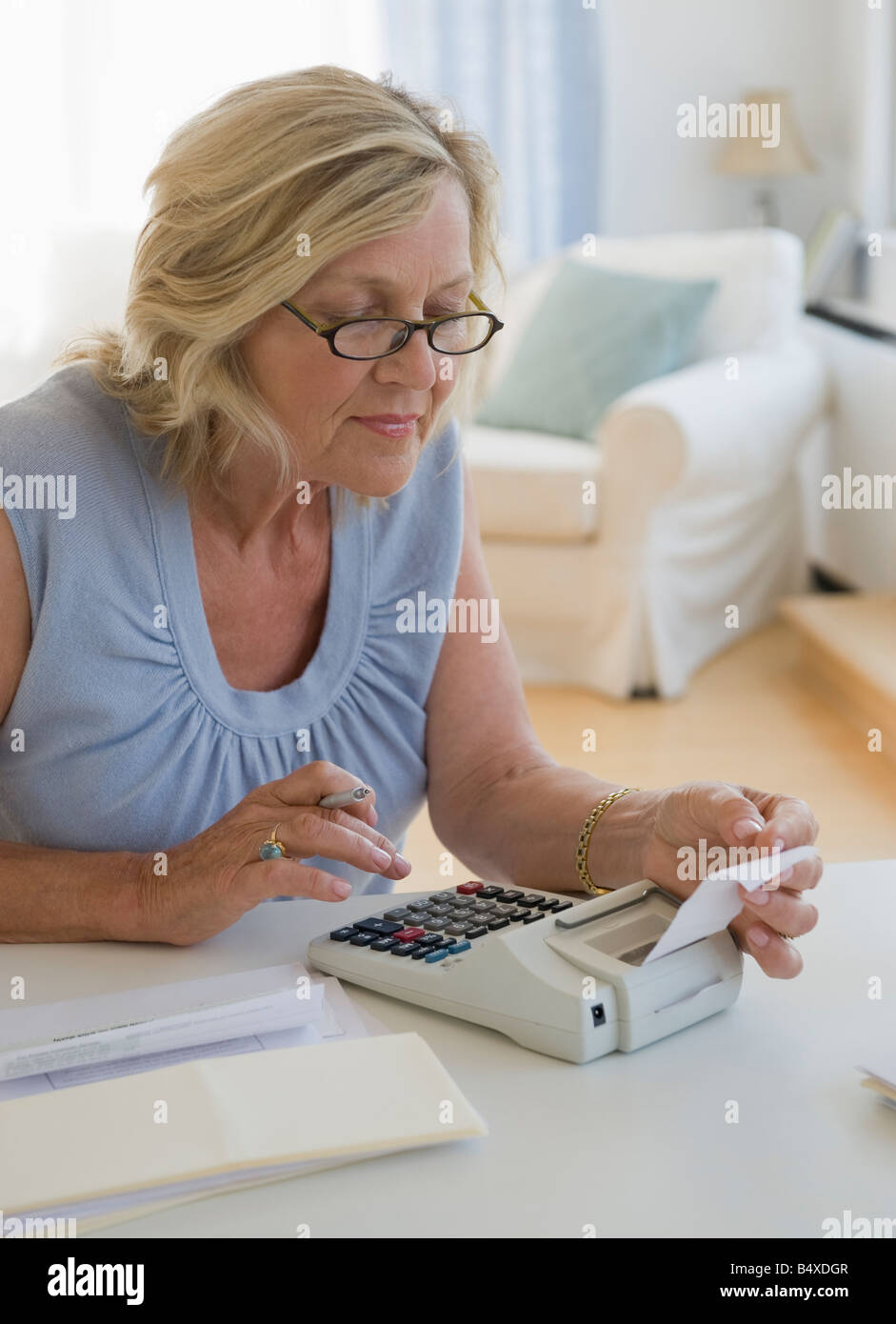 Woman using adding machine at home Stock Photo - Alamy