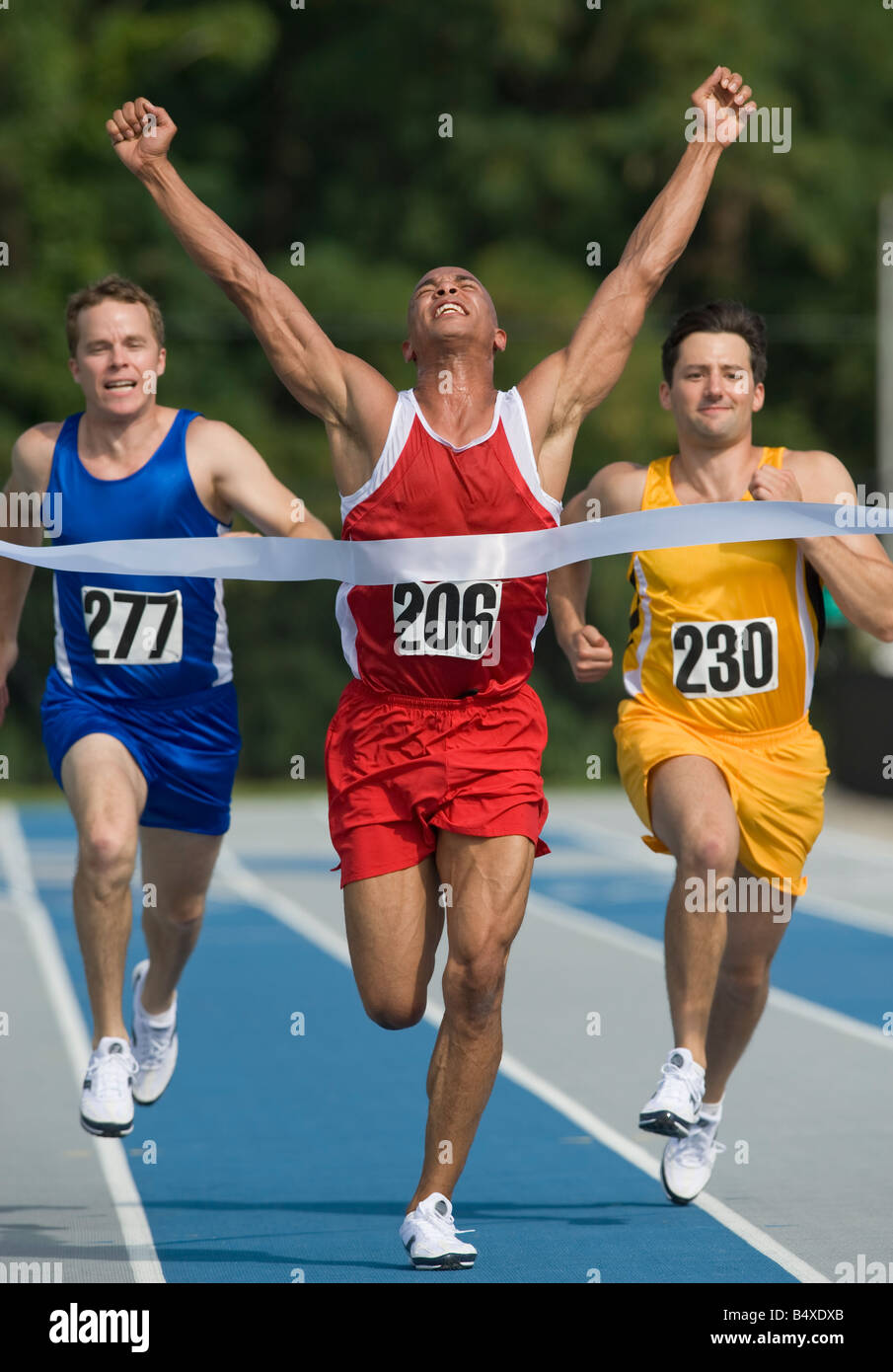 Runner breaking through finish line Stock Photo - Alamy