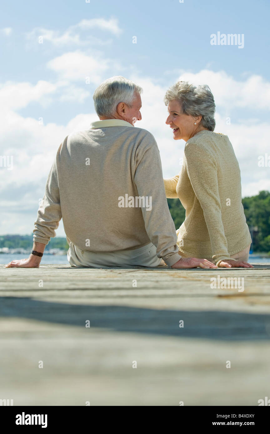 Senior couple sitting on dock Stock Photo - Alamy