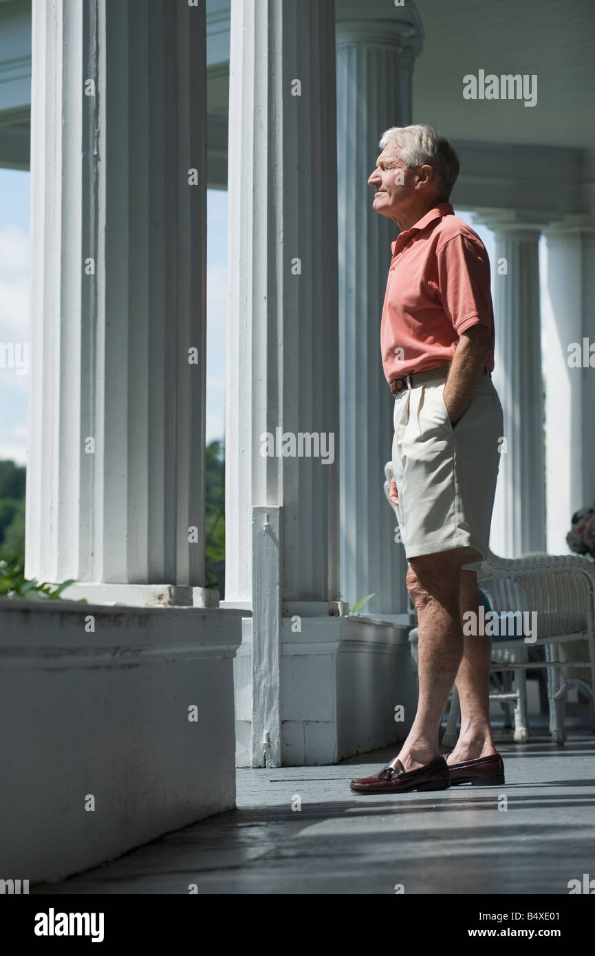 Senior man standing on porch Stock Photo