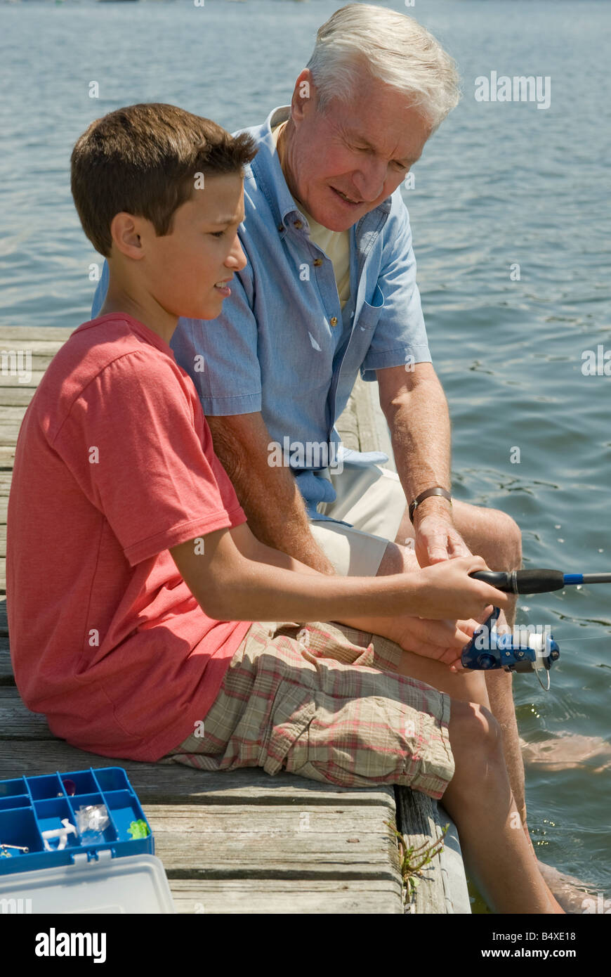 Grandfather and grandson fishing off dock Stock Photo