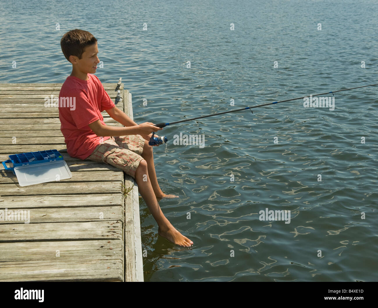 Boy fishing off dock Stock Photo