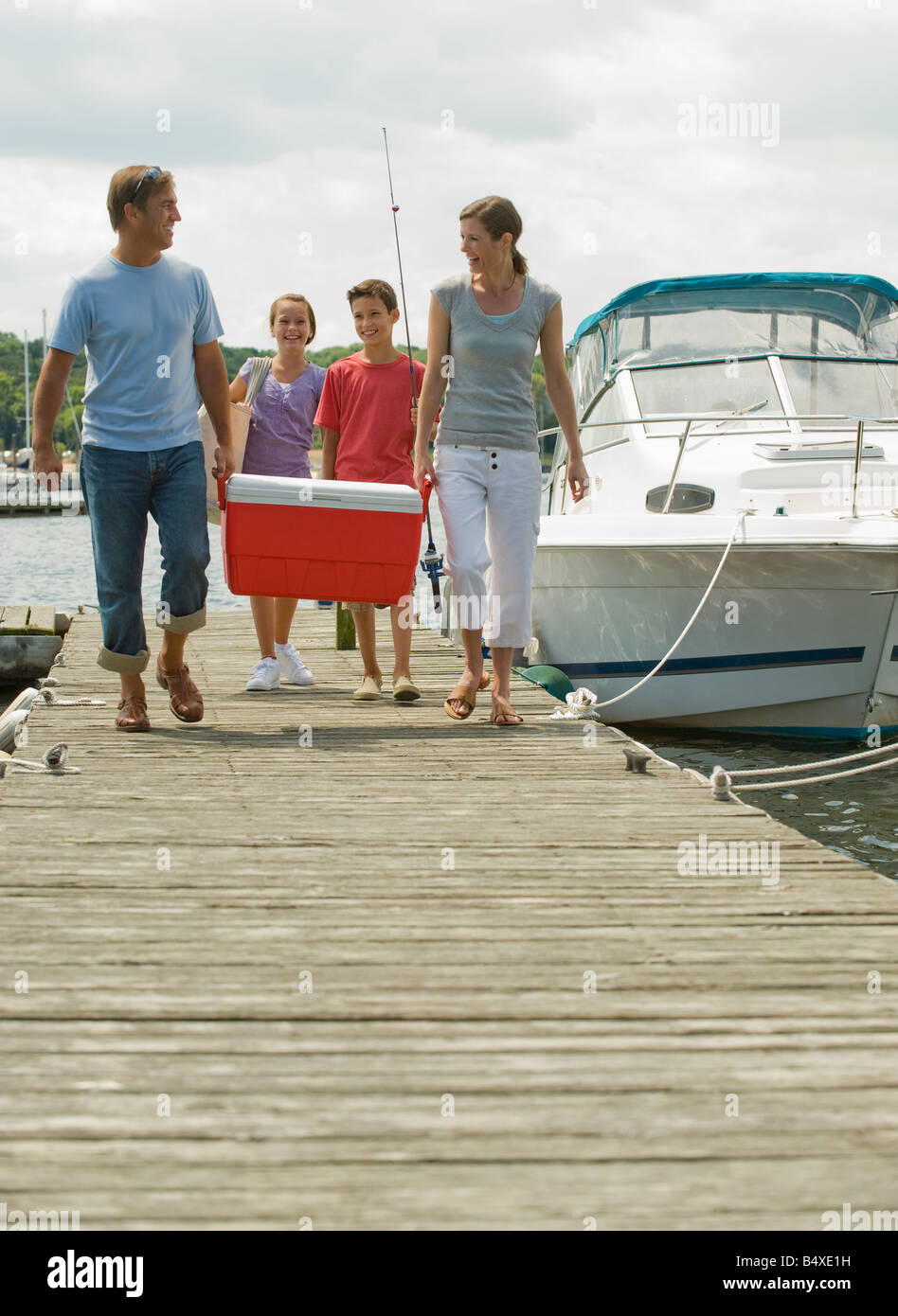 Family walking on boat dock with cooler Stock Photo