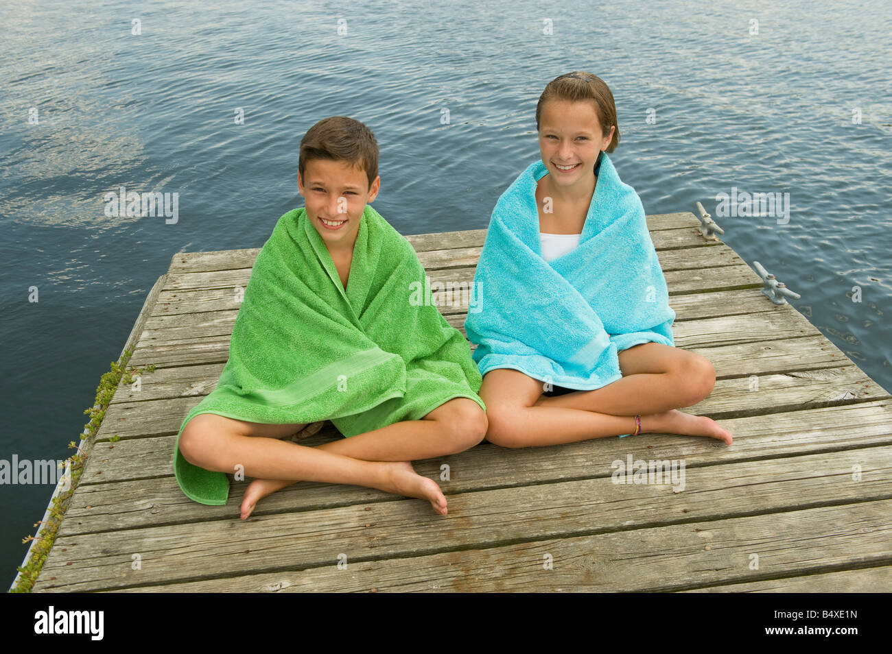 Children wrapped in towels on dock Stock Photo