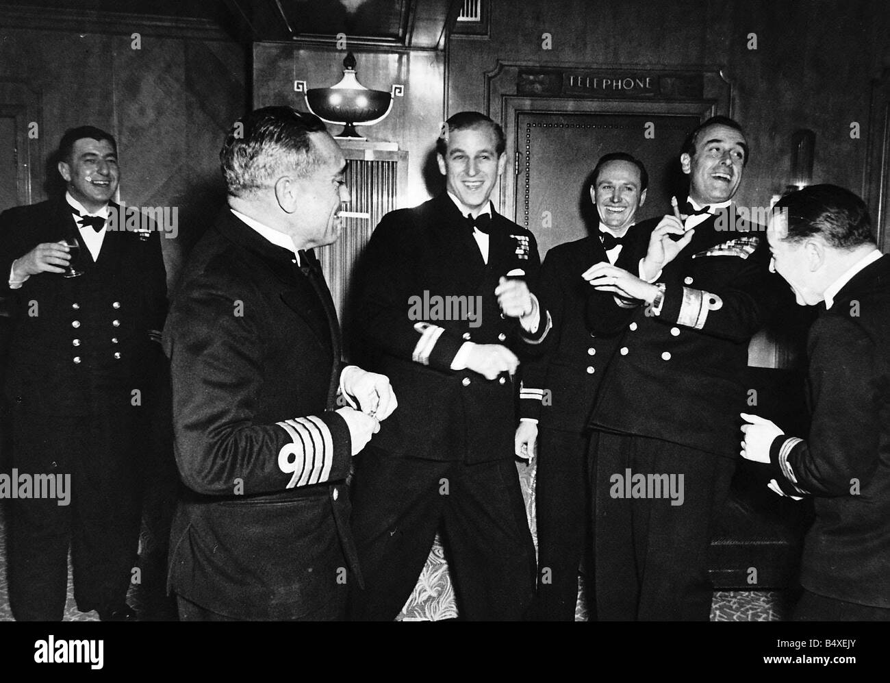 Prince Philip on the eve of his wedding with his Naval colleagues having a laugh With him is his uncle Earl Mountbatten holding Stock Photo
