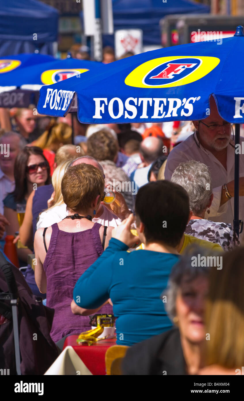 People sat drinking under FOSTERS umbrellas at Abergavenny Food Festival Stock Photo