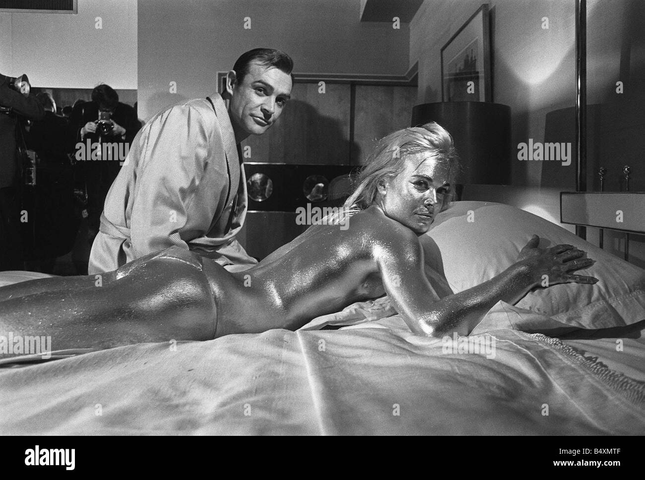 Film Goldfinger 1964 Shirley Eaton Sean Connery Pictured on set during filming covered in gold paint James Bond 007 Stock Photo