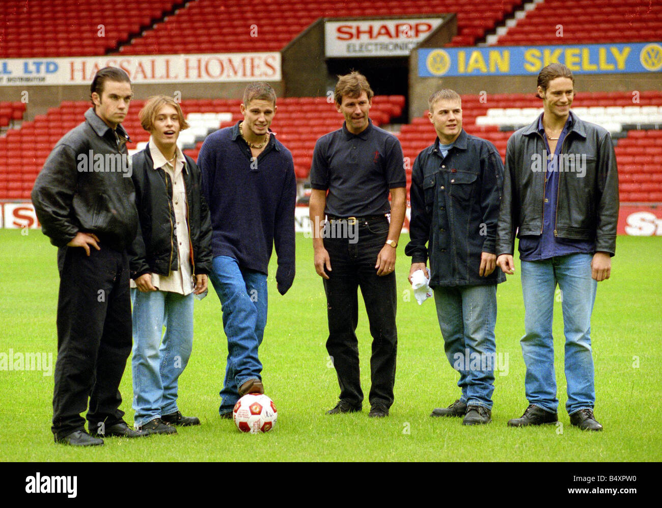 Members of pop group Take That left to right Robbie Williams mark Owen Jason orange Gary Barlow and Howard Donald with Bryan Robson of Manchester United at Old Trafford July 1993 Stock Photo
