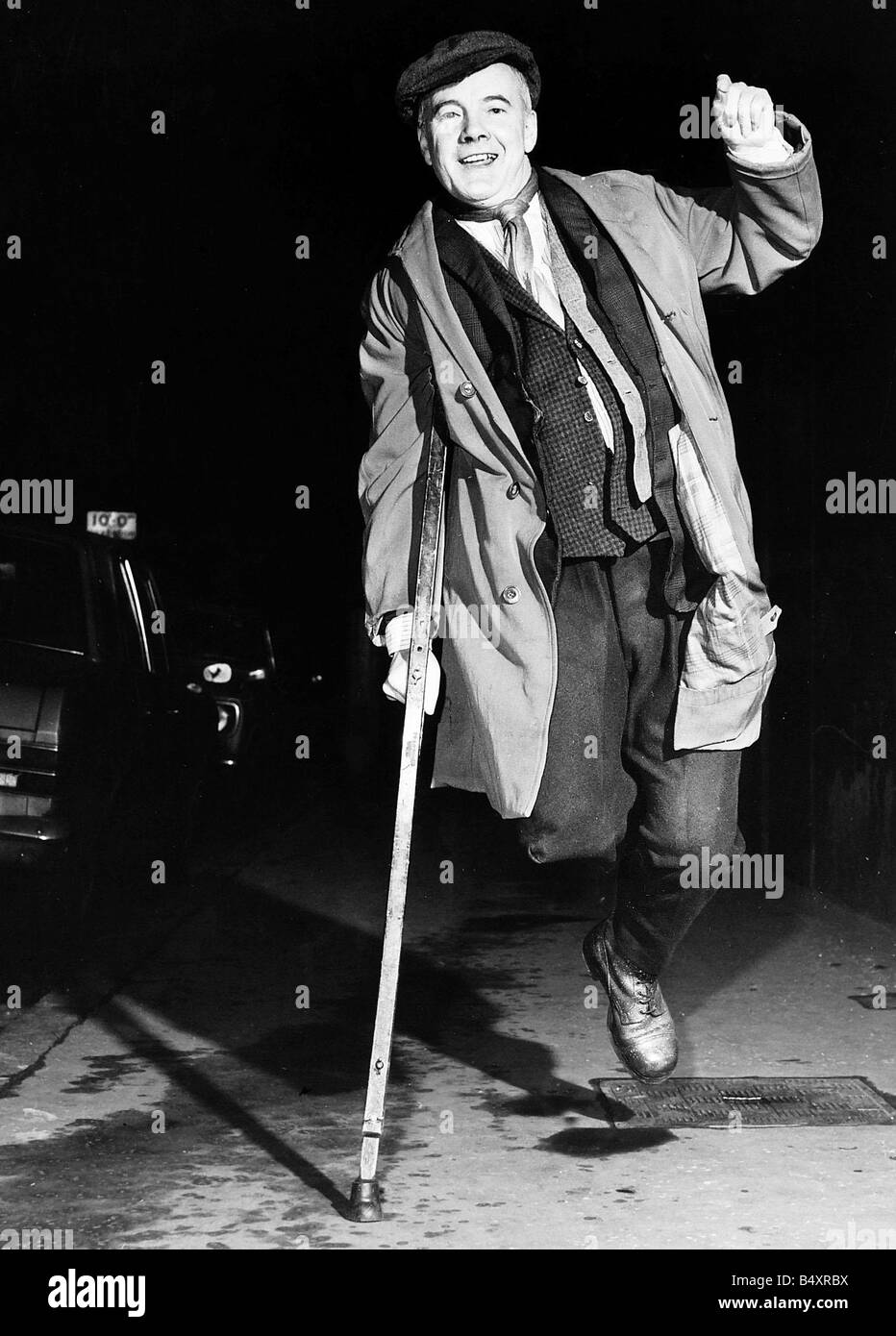 Fulton MacKay actor jumping in air with crutch on street star of stage play Willie Rough Stock Photo