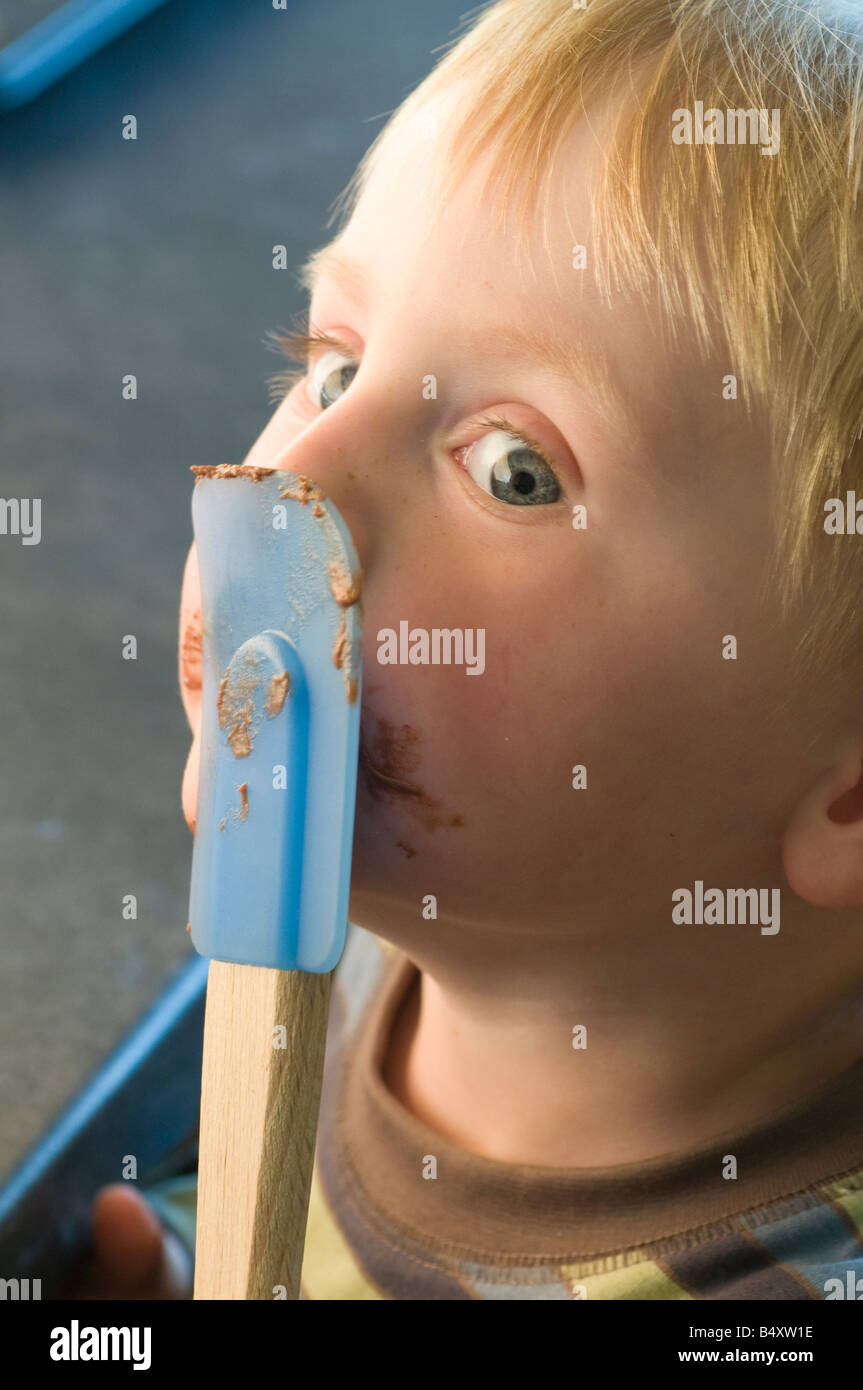 Boy licking chocolate of spatula Stock Photo