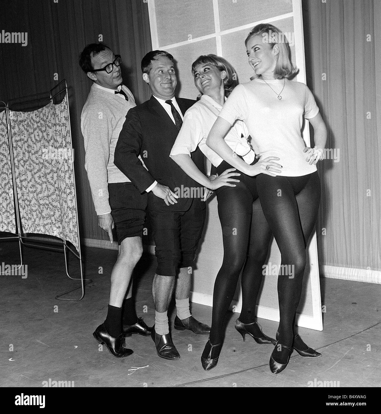 Eric Morecambe and Ernie Wise June 1965 clown it up with two chorus girls who include Jenny Lee Wright trouser legs rolled up Stock Photo