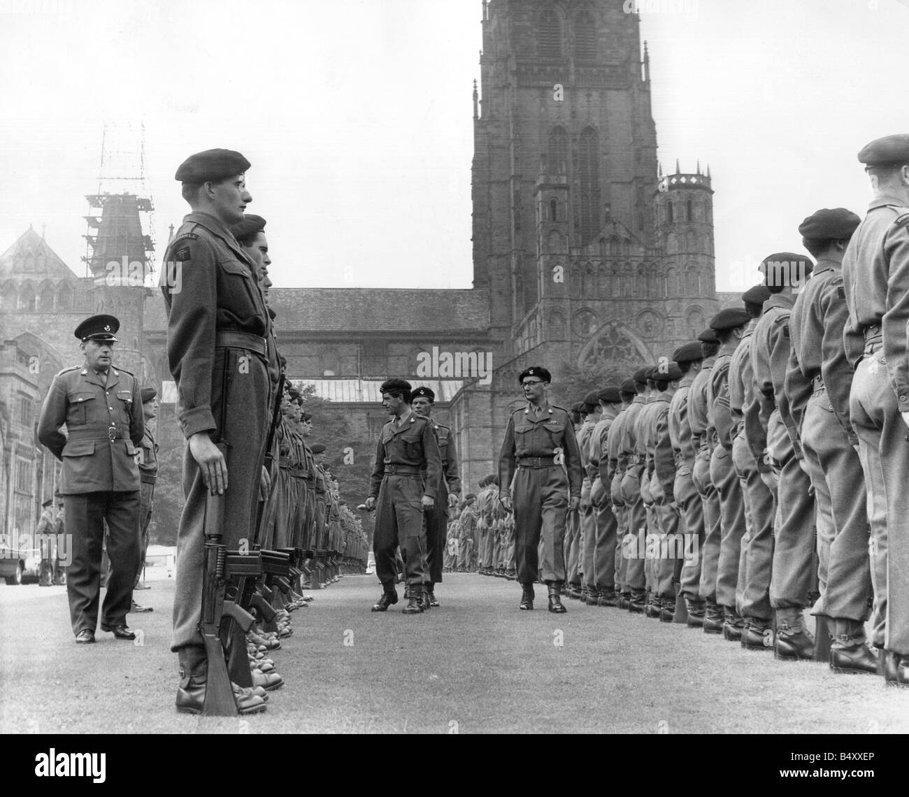 Inspecting officers move through ranks of soldiers from the Durham Light Infantry TA drawn smartly up in from Durham Cathedral Stock Photo