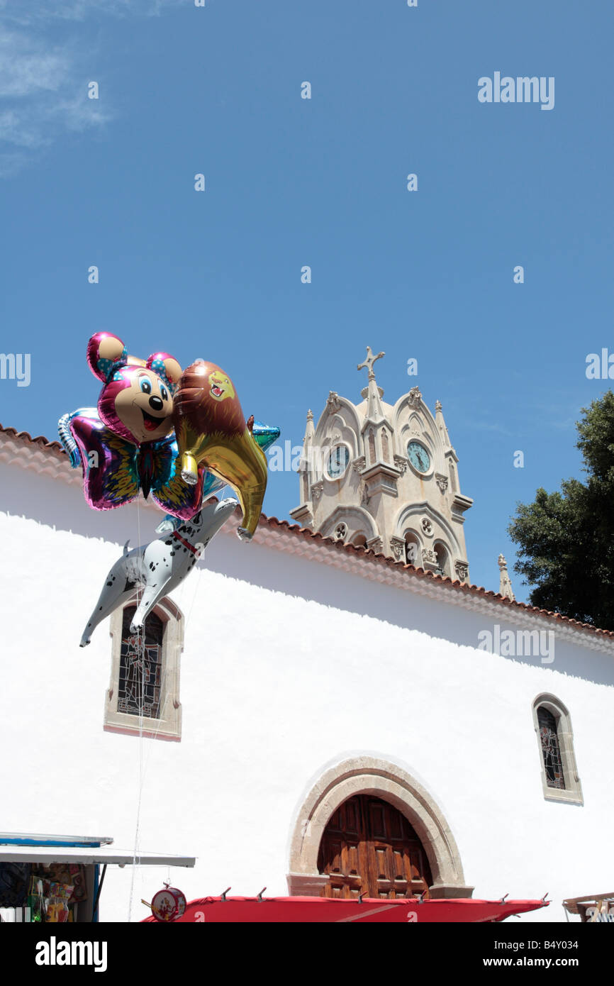 Helium balloons shaped as Disney characters float tethered to the roof of a stall next to the church,Guia de Isora, Tenerife Stock Photo