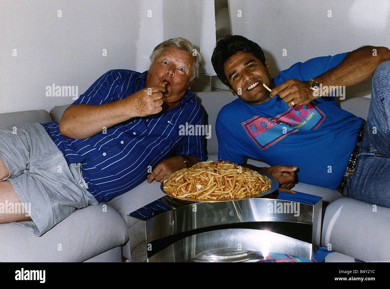 Benny Hill Actor Comedian With Fellow Actor Erik Estrada Eating A Plate Of Chips Stock Photo