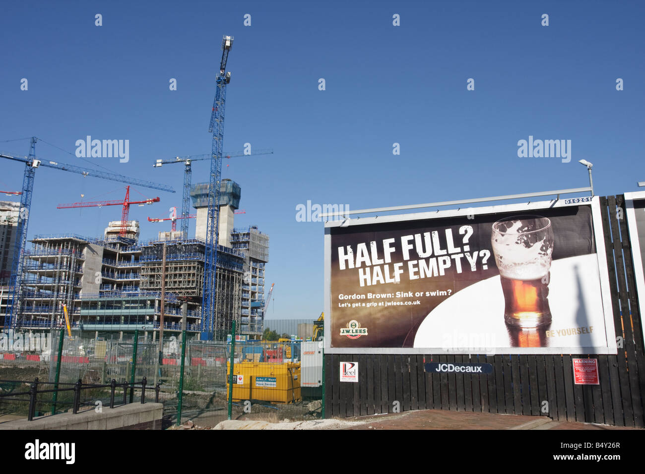 Half Full Half Empty Advertising Poster next to a Construction Site Economic Climate Stock Photo