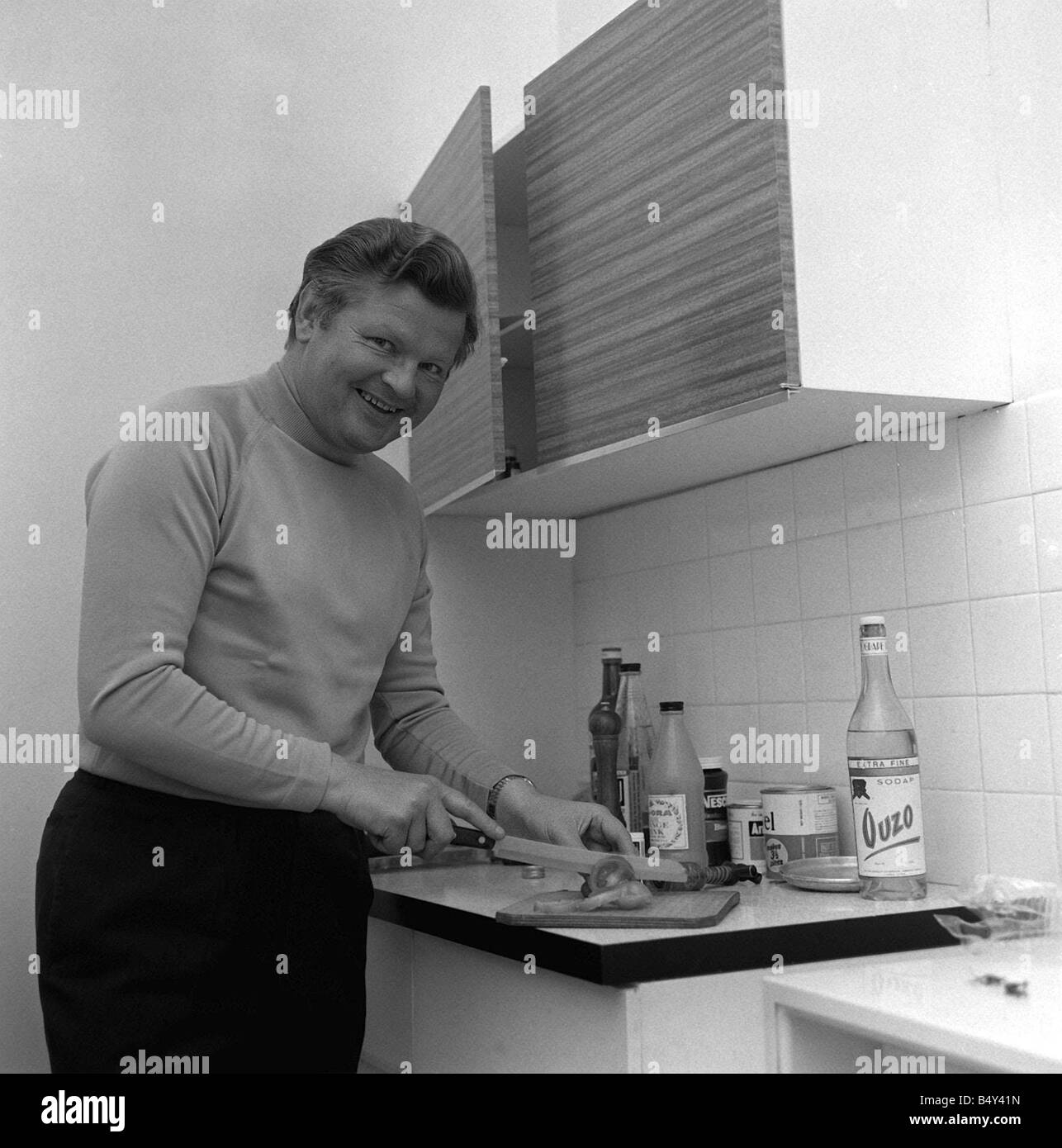 Comedian Benny Hill in his flat in the kitchen 1969 January 21st Marks the anniversary of the birth of British comedian Alfred Hill Better known as Benny Hill he appeared in comedy revues on stage on the radio and in 1949 on the television show Hi There In 1955 he started The Benny Hill Show featuring skits and songs from the bottoms and bosoms school of British humor Hill also appeared occasionally in films including Chitty Chitty Bang Bang In the 1970s The Benny Hill Show made it to the U S and Hill became an international star of TV comedy until his show was cancelled in 1989 Benny Hill Stock Photo