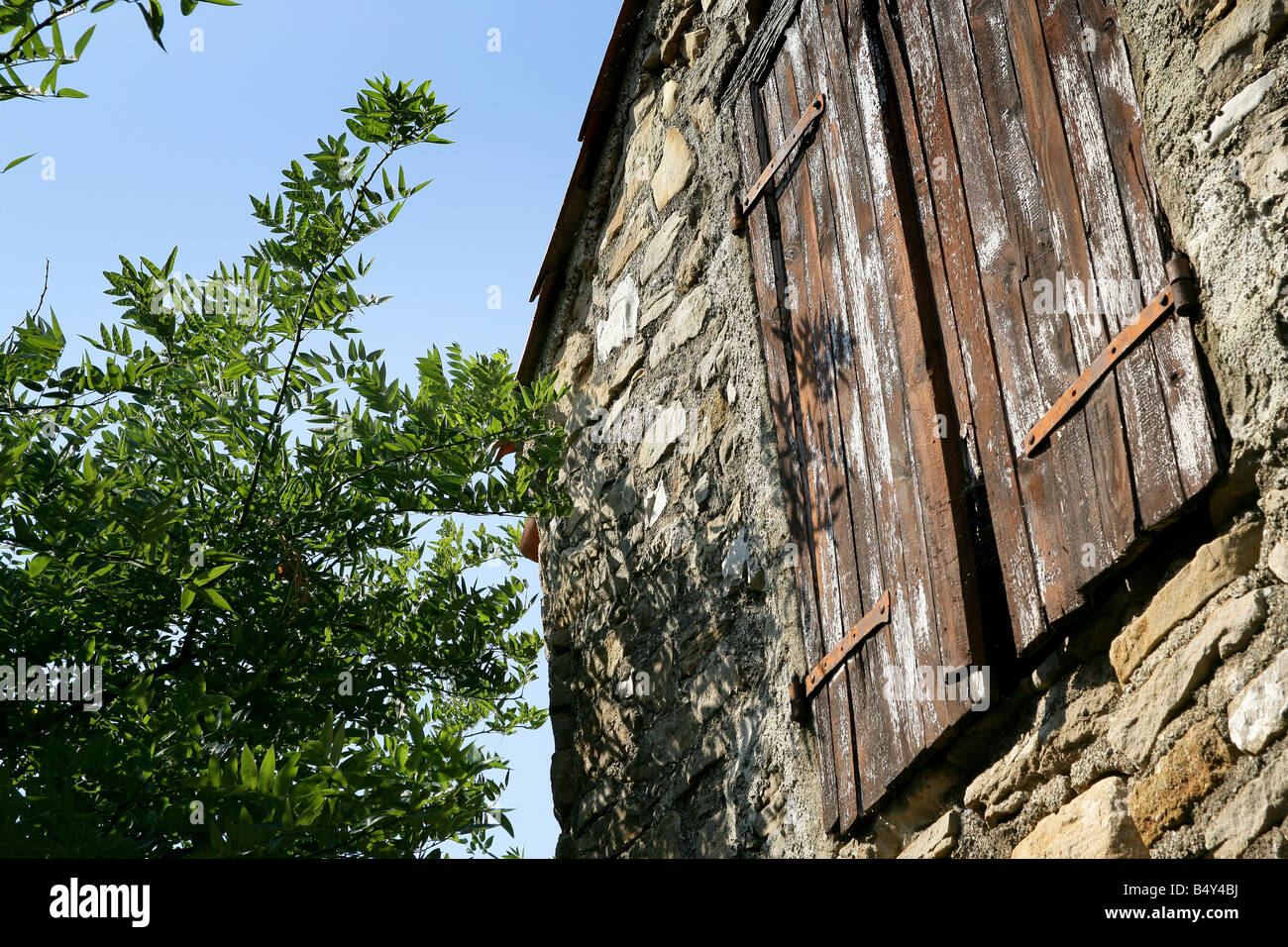 old stone house facade with wood shutters Stock Photo - Alamy