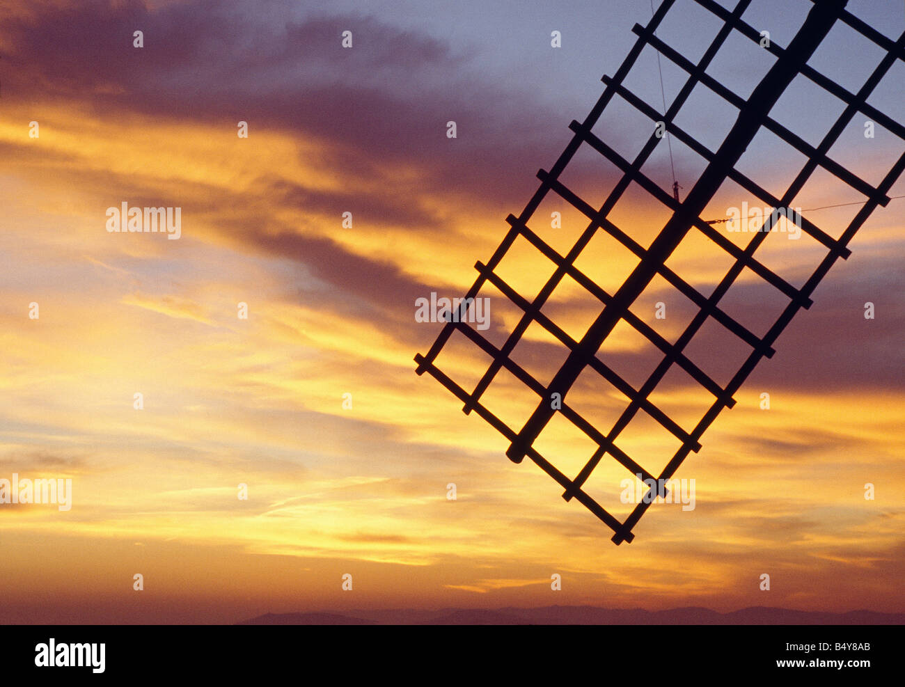 Windmill arm silhouette and sunset. Campo de Criptana. Ciudad Real province. Castile La Mancha. Spain. Stock Photo