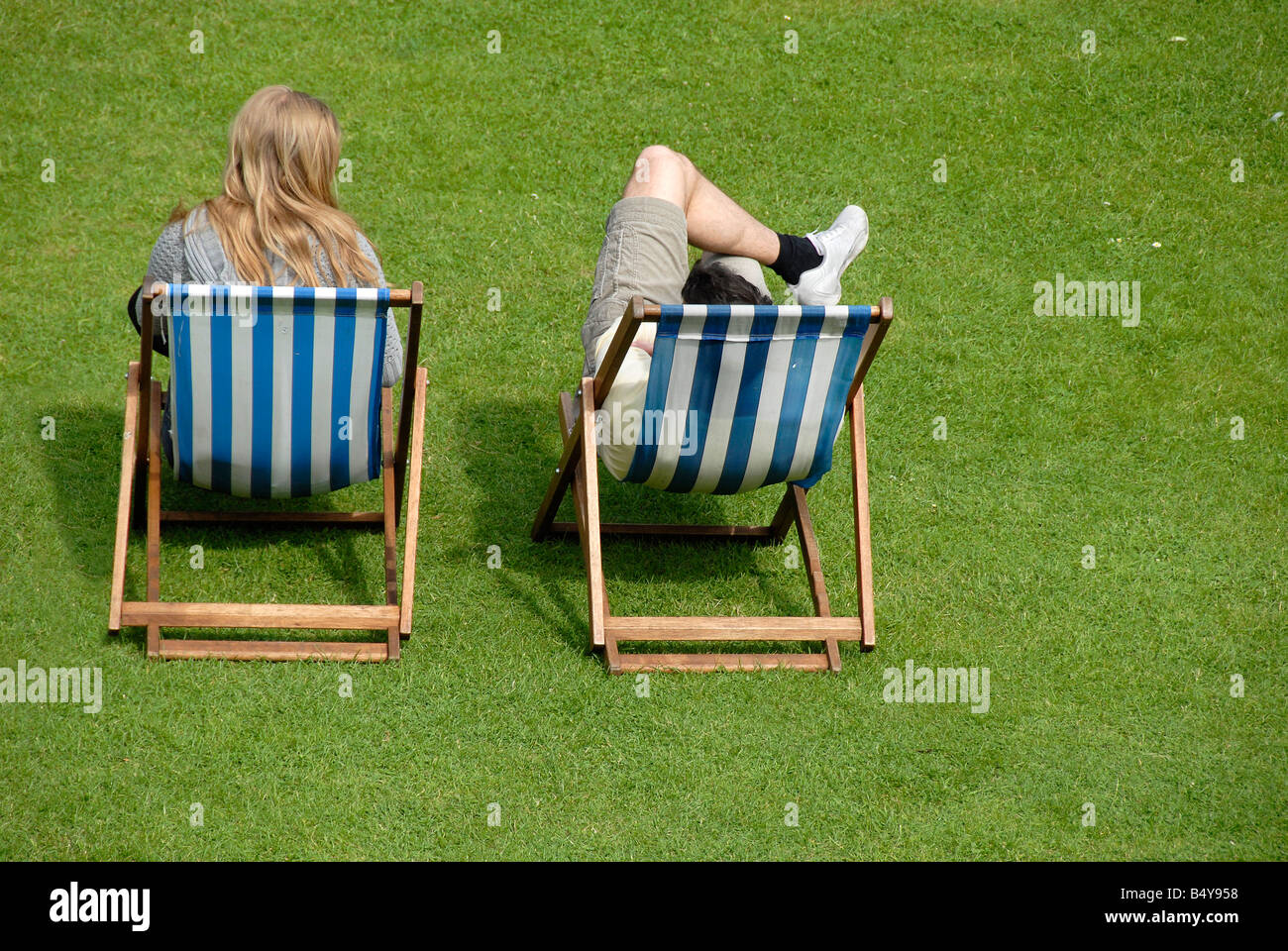 Man And Woman Sitting In Deck Chairs England Uk Stock Photo